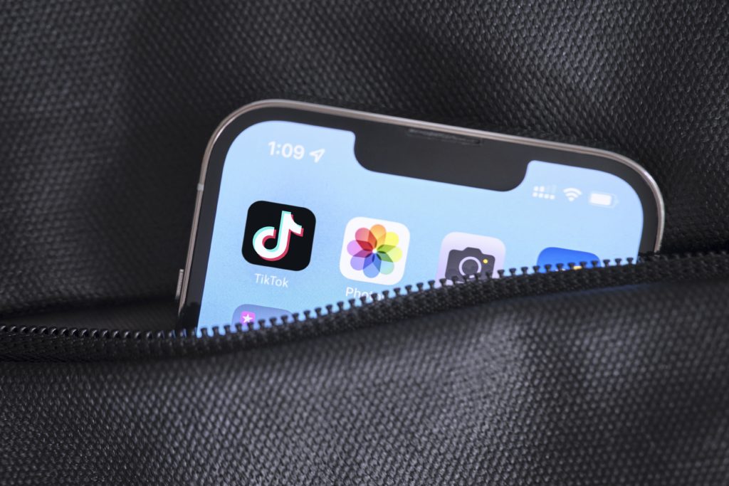 Mobil vytŕčajúci z čierneho vrecka s aplikáciou TikTok na ploche, ktorá je trendom digitálneho marketingu pre rok 2023