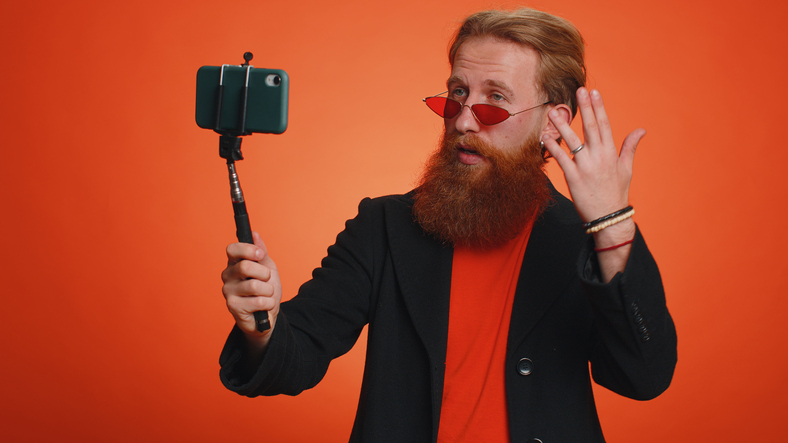 Ryšavý muž s bradou robí selfie na smartfóne